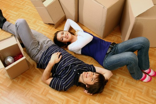 Movers carrying a wardrobe through a narrow Shoreditch stairwell